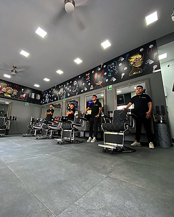 El equipo de 3F de pie en el salón, entre los sillones y bajo el mural