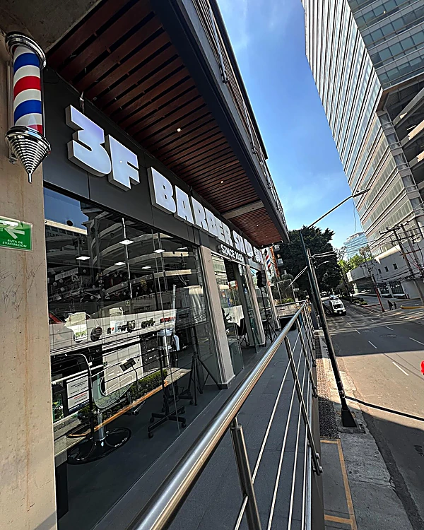 Pasillo del segundo nivel con barandal, el letrero 3F y el poste de barbero sobre la calle