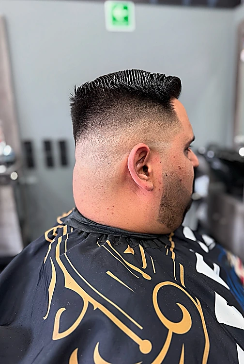 Skin fade con copete visto de lado, sin mostrar la cara